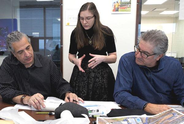 Three individuals collaborate during a design charrette